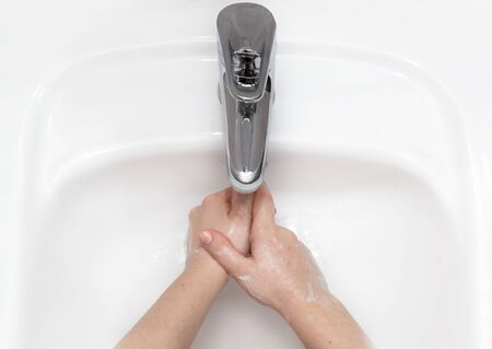 Woman use soap and washing hands under the water tap.の写真素材