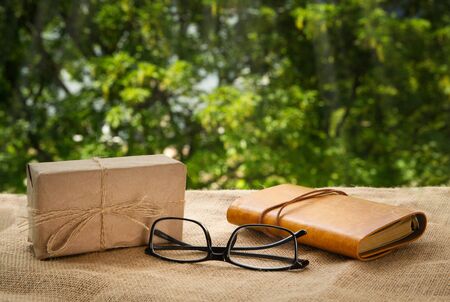 gift, glasses and leather notebook on the window in the garden.の写真素材