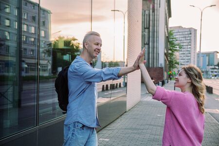 Meeting of two friends on a city street in the evening.の写真素材