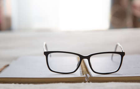 Image of an open notebook placed in bed with glasses at the topの写真素材