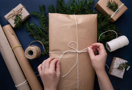 Hands tie a rope on a package with giftsの写真素材