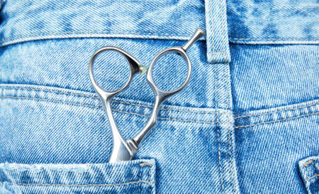 professional hairdressing scissors lie in the pocket of jeans.の写真素材