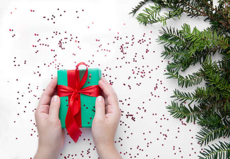 Hands hold Christmas gift with red ribbonの写真素材