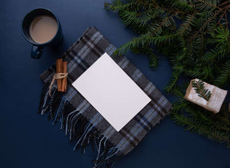 a sheet of paper lies on a table with a scarf and a cup of coffeeの写真素材