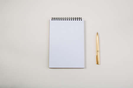 White notepad with golden pen on light table, view of free space for textの写真素材