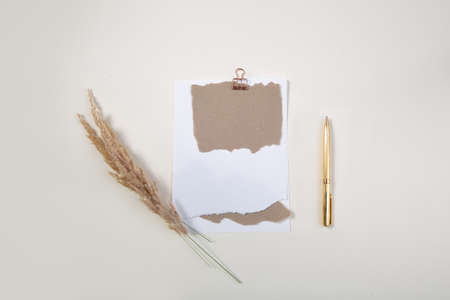 White notepad mockup with golden pen on light table .top view .の写真素材