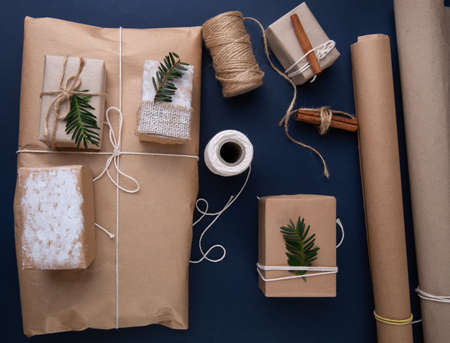 Christmas gifts on blue background next to wrapping paperの写真素材