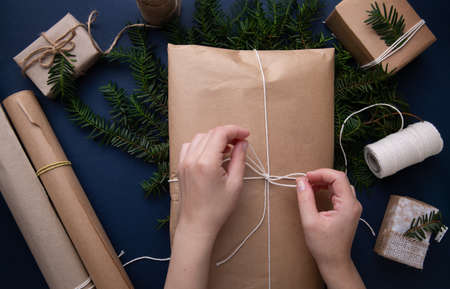 Hands tie a rope on gifts for Christmasの写真素材