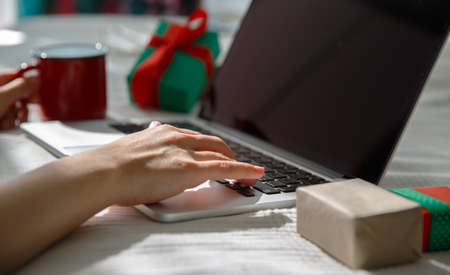 Woman Hands hold red mug and using digital tablet computer