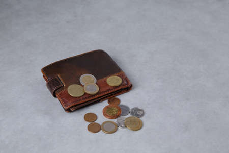 The wallet lies on the Light table and metal coins are scattered next to itの写真素材