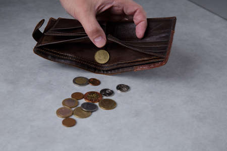 The hand of a man who is pouring coins from a walletの写真素材