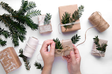 hands wrapping gifts for christmas holidays. next to threads and boxesの写真素材