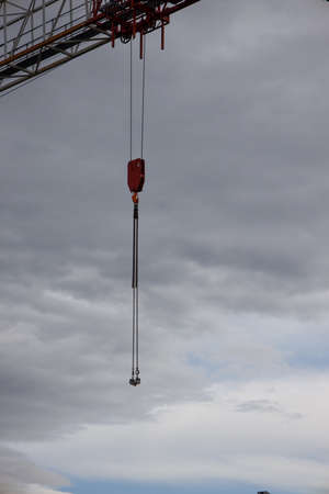 part of a construction crane against a blue sky with clouds, eveningの写真素材