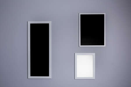 Poster mockup with three frames on empty grey wallの写真素材