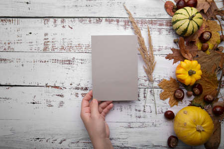 Woman hand holds grey card on wooden backgroundの写真素材