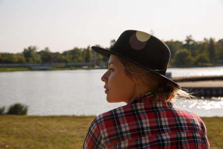 young girl in a felt hat on the background of the riverの写真素材