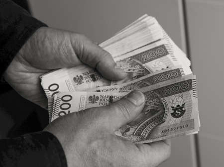 male hands holding a bundle of large banknotesの写真素材