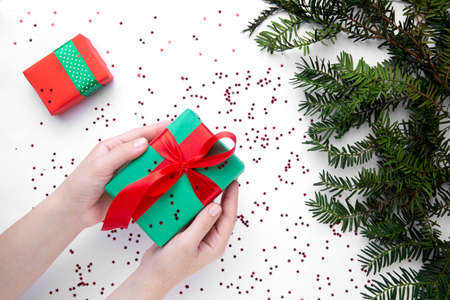 Hands hold Christmas gift with red ribbonの写真素材