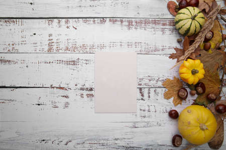 blank card on wooden table next to autumn compositionの写真素材