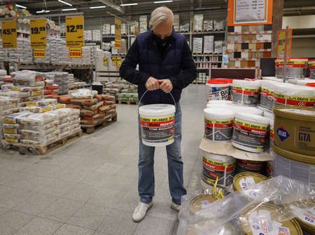 man in a medical mask selects paint in the OBI store. Poland, Opole, 08.10.のeditorial素材