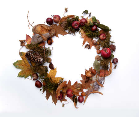autumn wreath of yellow leaves of apples and chestnuts on a white backgroundの写真素材