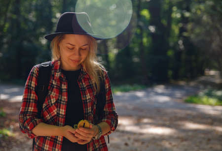 young caucasian woman in hat looks at the compass in her handの写真素材