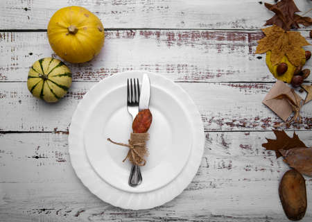 autumn composition with pumpkins and cutlery on an old tableの写真素材