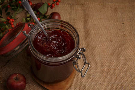 jar of strawberry jam is on the table, covered with a rough country tableclothの写真素材
