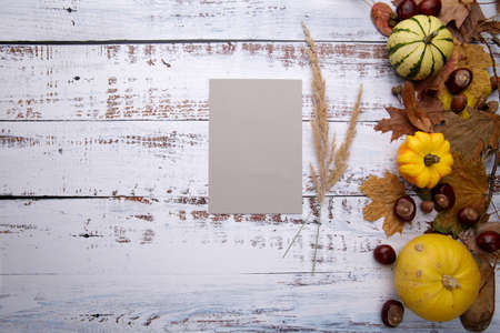 blank card on wooden table next to autumn composition and spikeletsの写真素材