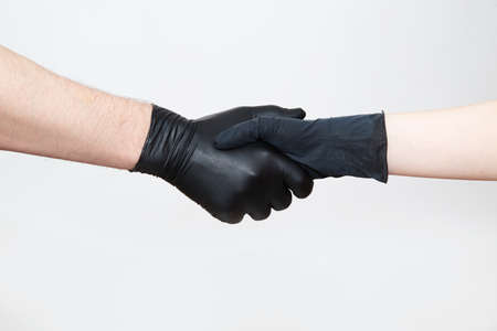 Handshake with black gloves during quarantine and epidemic.の写真素材