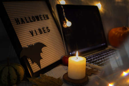 White candle on wooden board with cookies stand on tableの写真素材