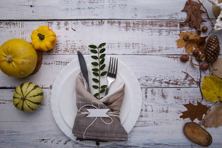 composition on the table with yellow leaves, cutlery and pumpkinsの写真素材