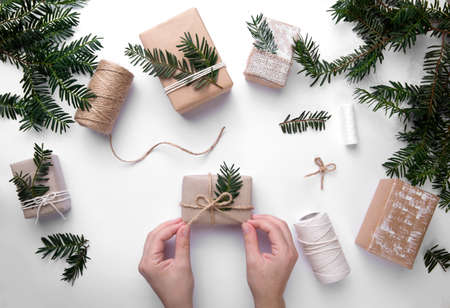 hands wrapping gifts for christmas holidays. next to threads and boxesの写真素材