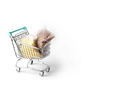 miniature shopping cart filled with bags of buckwheat and milletの写真素材