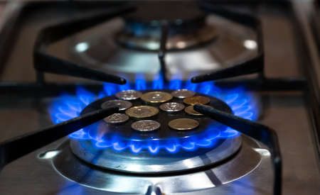 coins lie on the stove burner on which the gas is turned on