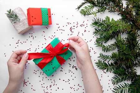 Hands hold Christmas gift with red ribbonの写真素材