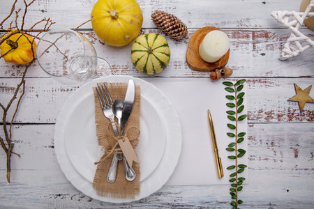 Autumn composition with a plate for cutlery, pumpkins and yellow leaves .の写真素材
