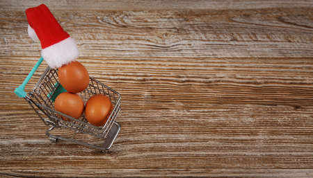 miniature grocery cart with chicken eggs and little Santa hat. selective focusの写真素材