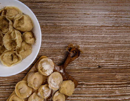 plate of homemade dumplings, and not boiled standing on the board. selective focus .の写真素材