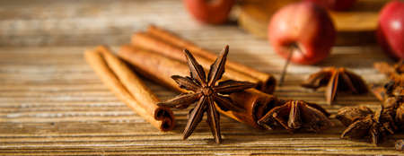 anise stars and cinnamon sticks with apples on a wooden table. selective focus