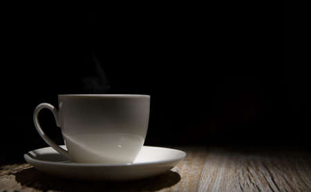 cup and saucer on a wooden table at dusk. selective focusの写真素材