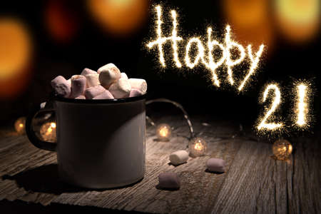 mug of cocoa with marshmallows and happy 21 next to it. selective focusの写真素材