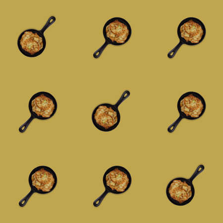 Seamless pattern of fried potato pancakes in a pan. Delicious and satisfying food. beige isolated background. Print and design conceptの写真素材