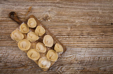 dumplings with meat stand on a board, on wooden table. selective focusの写真素材