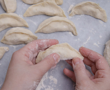 cropped image of the hands of a child who learns to make dumplings with potatoes. selective focus.High quality photoの写真素材