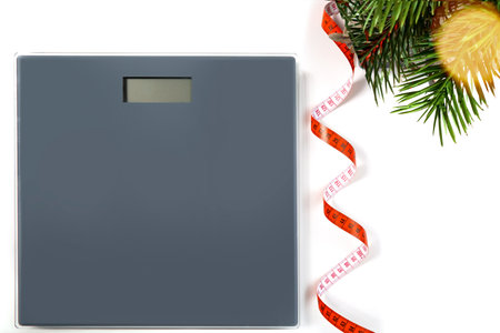 scales, flexible meter and Christmas tree branch with bokeh garland on the white background. selective focus.High quality photoの写真素材