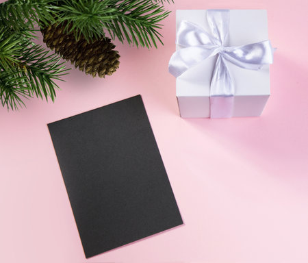 gift box with white silk ribbon fir branch with pine cone and dark card for text .concept holiday.selective focus.の写真素材