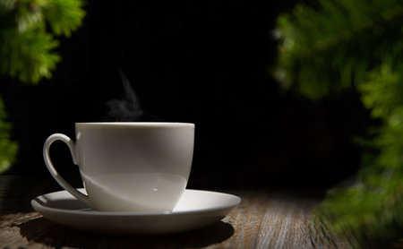 a cup of tea standing on a wooden table and around a spruce sprig.selective focus. High quality photoの写真素材