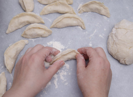 cropped image of the hands of a child who learns to make dumplings with potatoes. selective focus.High quality photoの写真素材