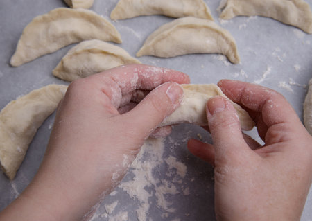 the hands of a child who learns to make dumplings with potatoes. selective focus.の写真素材